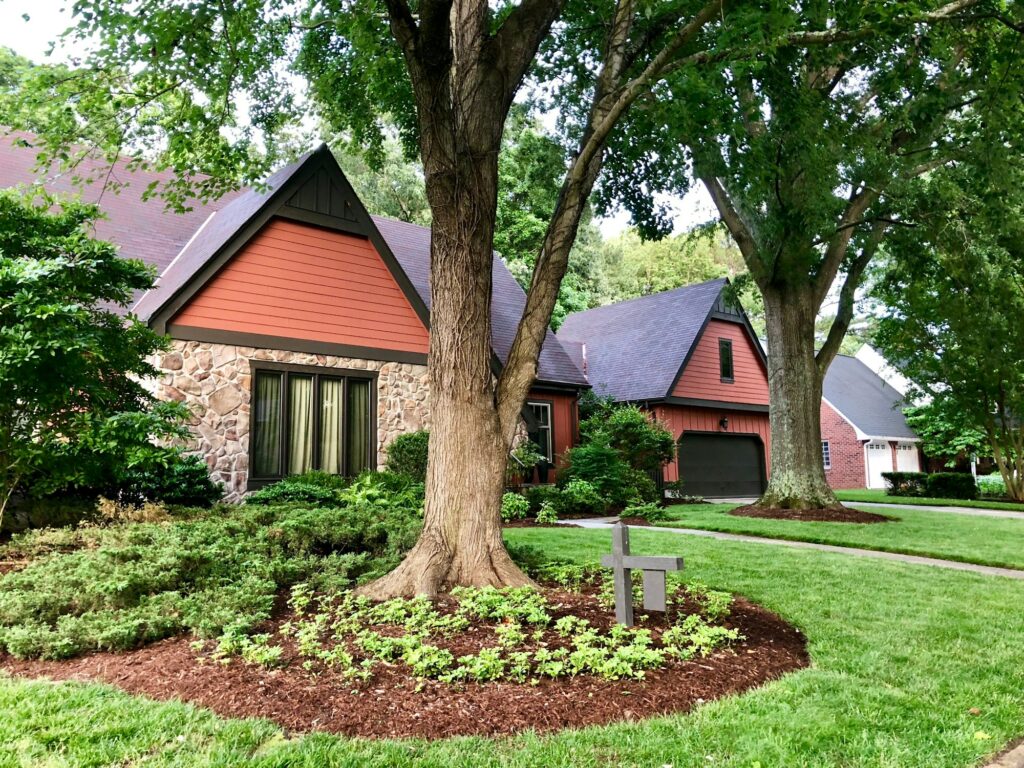 Beautiful neighborhood stone facade house with well kept landscaping.